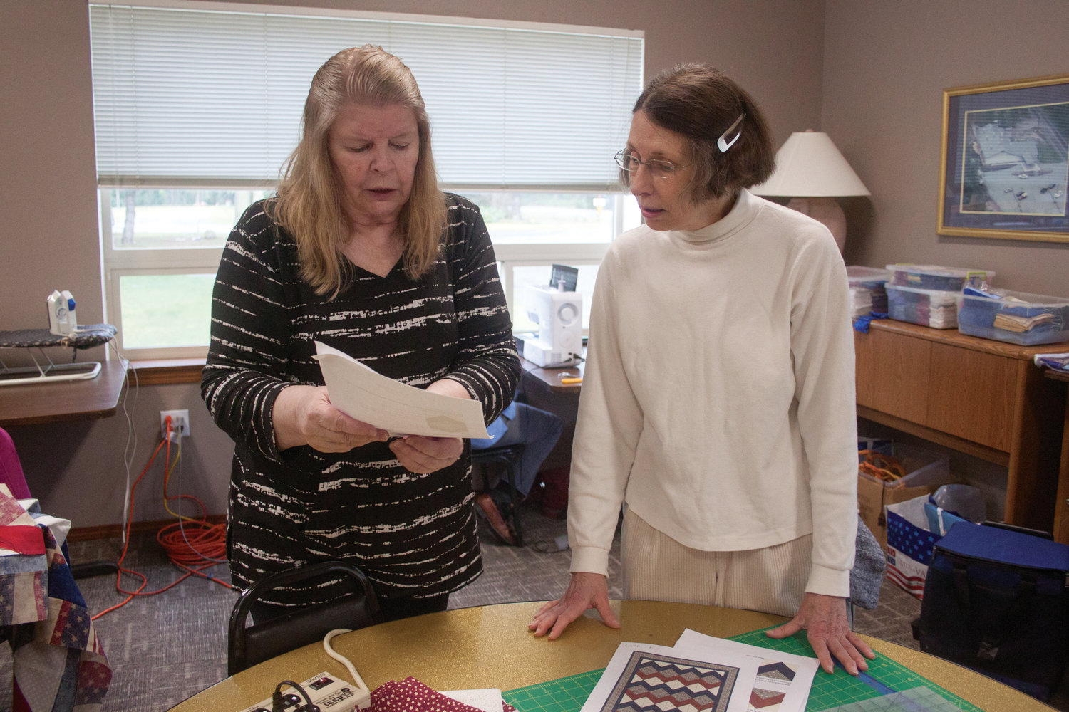 Linda Fultz and Lill Greenwood plan how to assemble their quilt tops to match the patterns.